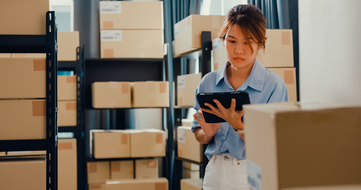 Warehouse worker using a tablet beside stock