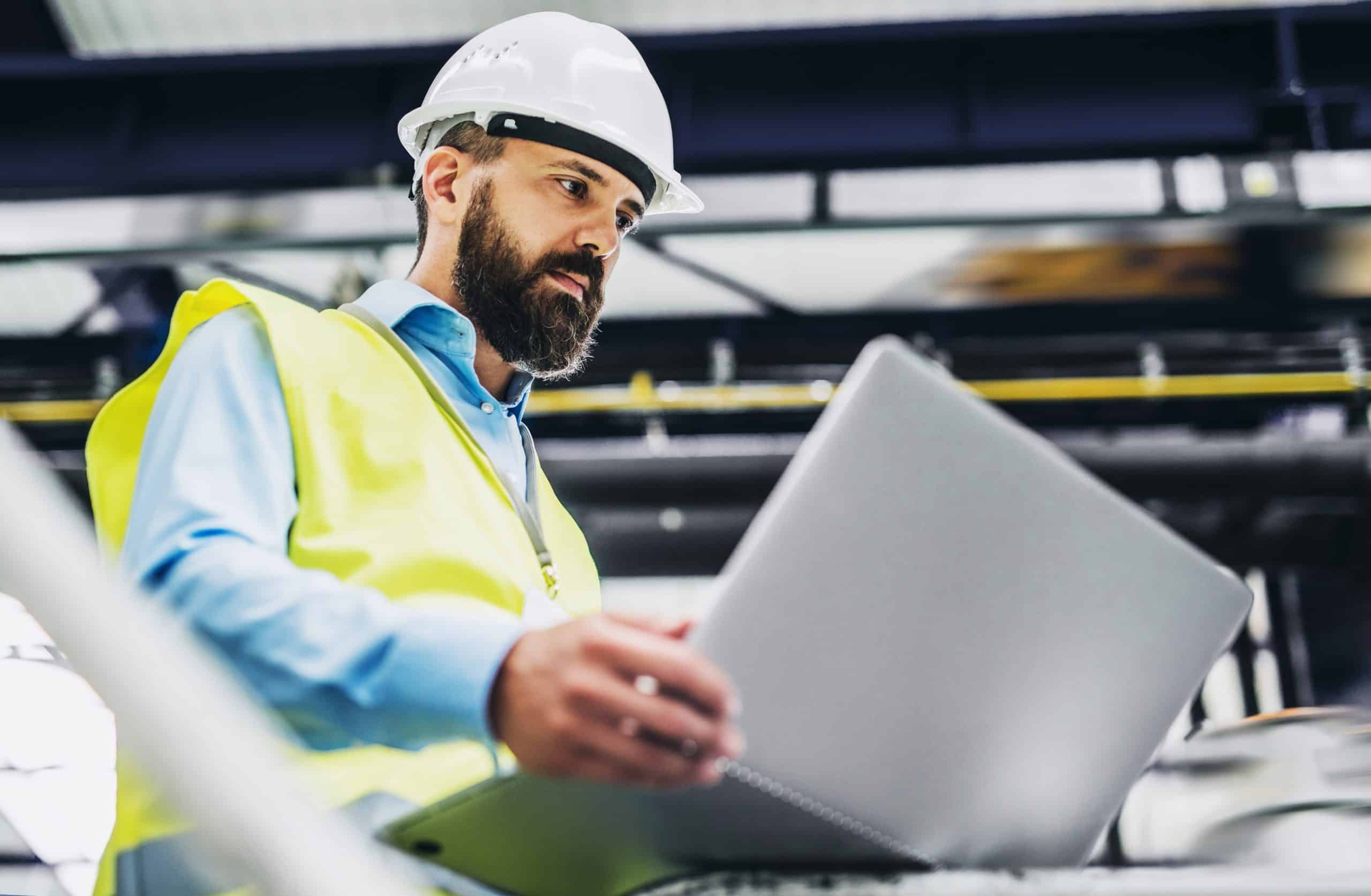 Warehouse manager checking live stock on a tablet in the aisle