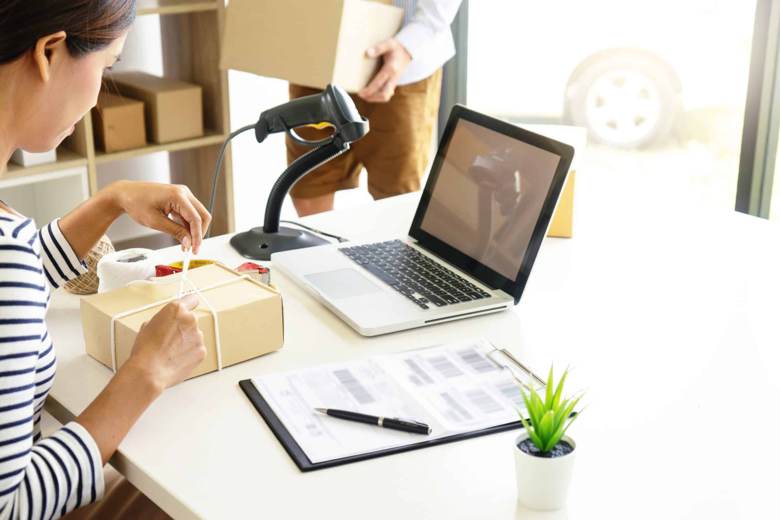 Warehouse worker scanning a barcode on boxed stock with a handheld scanner